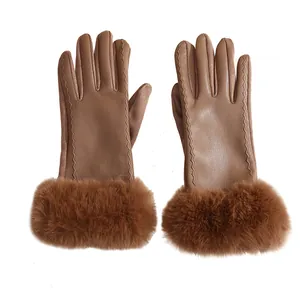 Detailed view of women's winter brown suede and PU leather gloves with plush faux fur cuffs