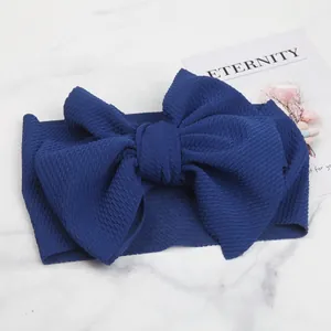 Detailed macro view of the dark blue textured corn grain fabric on a large bow baby headband