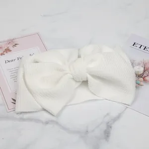 Close-up of white bubble texture child headband with a large decorative bow