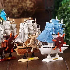 Detail view of three Mediterranean-style wooden sailboat models on a desk