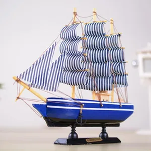 Detailed view of a wooden Mediterranean sailing ship model with blue striped sails.