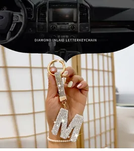 Close-up of sparkling rhinestone letter M keychain featuring a luxury glitter strap