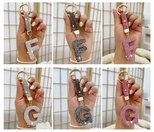 Detailed view of rhinestone-encrusted alphabet F and G keychains in multiple colors