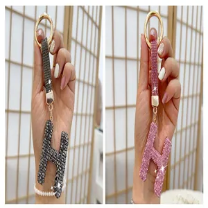 Detailed macro view of two sparkling rhinestone-encrusted letter H keychains in black and pink