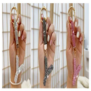 Close-up of sparkling rhinestone-encrusted letter Y keychains in three vibrant colors.