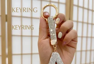 Detailed close-up view of a sparkling rhinestone initial A keychain held by a human hand