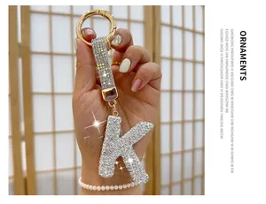 Detail of rhinestone-encrusted letter K keychain with shimmering gold strap and ring.