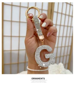 Close-up detail of rhinestone letter G keychain with sparkling gold-tone hardware