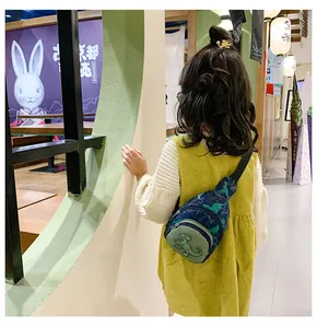 Rear view of child wearing cute dinosaur chest bag in a stylish casual outfit