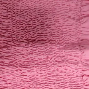 Vue macro montrant la texture du tissu smocké rose de l'ensemble jupe mode