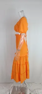 Vue latérale d'un ensemble d'été orange deux pièces avec taille smockée et jupe à volants