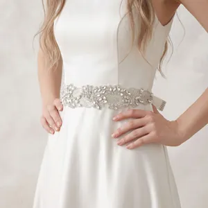 Detailed view of an elegant bridal wedding rhinestone sash on a white satin ribbon belt