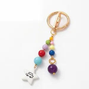 Detailed view of a minimalist colorful bead keychain featuring a cute white star car charm