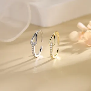 Detailed view of gold and silver knotted adjustable rings with sparkling zircon accents