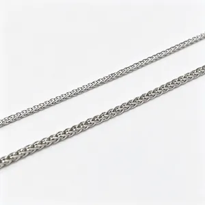 Gros plan d'une chaîne Chopin en argent sterling S925 montrant une texture tressée.