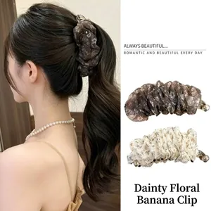 Close-up of floral banana clip securing a high ponytail for volume.