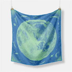 Detail view of an intricate celestial moon and horse pattern on a blue silk square scarf.