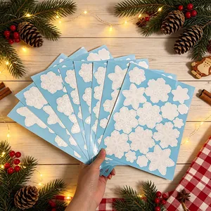 Gros plan de feuilles bleues avec autocollants de flocons de neige pour décor de Noël.