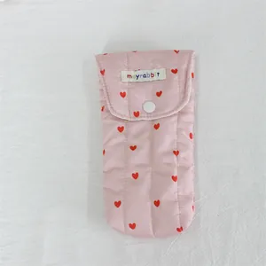 Detail of pink quilted heart pattern storage bag with button closure.
