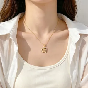 Collier élégant en acier titane avec pendentif double cœur serti de zircons sur mannequin.