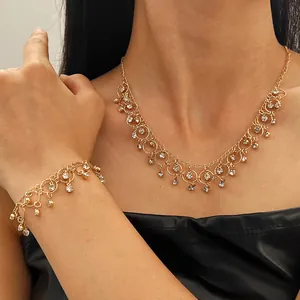 Macro detail of gold geometric choker necklace and bracelet set with sparkling zircon tassels.