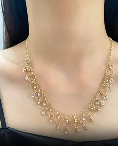 Close-up of an elegant gold tassel necklace with sparkling zircon drops on a model's neck