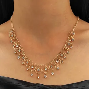 Close-up of elegant gold-toned zircon fringe necklace worn by a model for a chic look