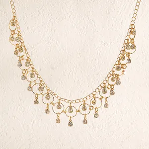 Close-up of golden geometric tassel necklace with sparkling zircon drop charms