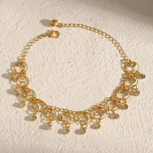 Close-up detail of a gold necklace featuring geometric fringe and sparkling zirconia drops