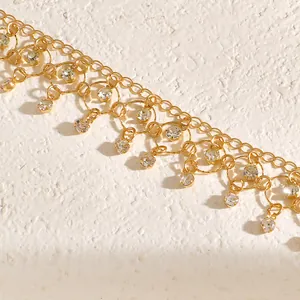 Macro view of gold-plated necklace featuring sparkling zirconia tassels and geometric rings