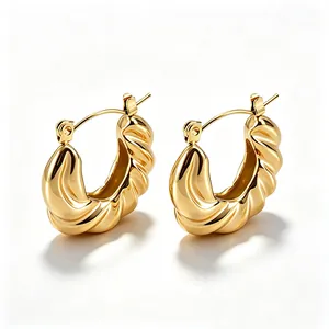 Detail von vergoldeten 18K Edelstahl-Creolen im gedrehten Croissant-Design-Stil.
