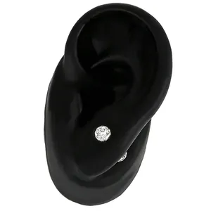 Close-up detail of sparkling silver pave crystal ball stud earrings on model ear
