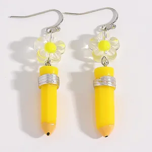Creative yellow pencil-shaped drop earrings featuring a clear flower charm detail
