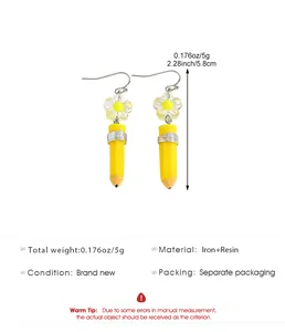 Detail view of yellow pencil drop earrings with size and material specifications