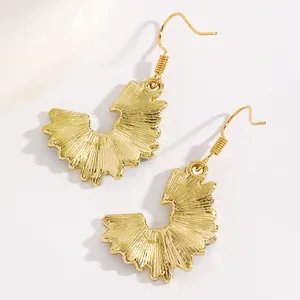 Detailed macro view of gold-tone pencil shaving style fan-shaped dangle earrings