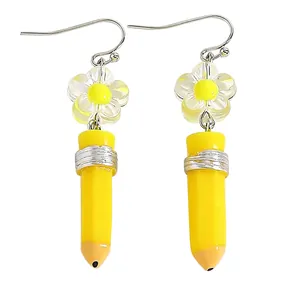 Macro view of cute yellow pencil earrings with flower detail and enamel finish.