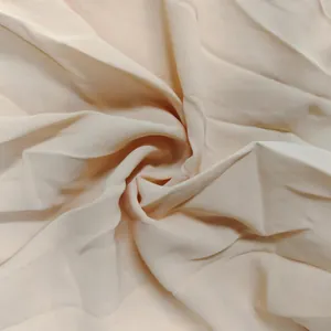 Macro detail showing the soft texture and draping of beige fabric for summer casual wear.