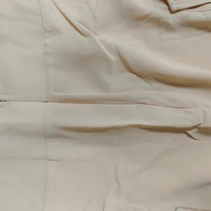 Close-up of beige fabric texture and stitching for women's summer casual two-piece set