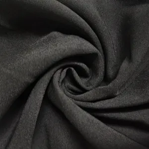 Macro close-up view showing the soft texture and elegant drape of black garment fabric