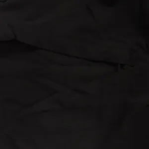 Detailed macro view showing the texture and folds of the black solid color fabric material