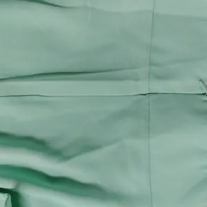 Detailed close-up showing the mint green fabric texture and invisible zipper closure