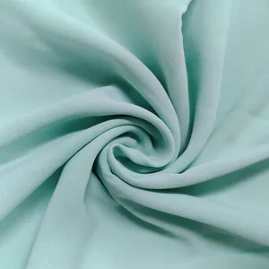 Macro detail view of lightweight mint green breathable fabric showing subtle crepe weave