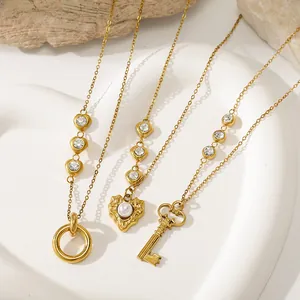 Close-up of vintage gold stainless steel necklaces with heart, key, and circle pendants.
