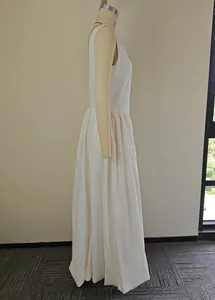 Side view of an elegant white sleeveless maxi dress displayed on a professional mannequin.