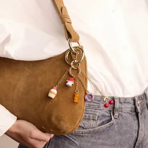 Detailopname van een kleurrijke acryl tassenhanger met motieven van gummibeertjes en donuts