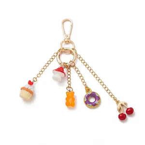 Gedetailleerd overzicht van gouden sleutelhanger met cupcake en donut bedeltjes