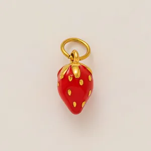 Detail van een levendige rode aardbeien hanger met gouden accenten.
