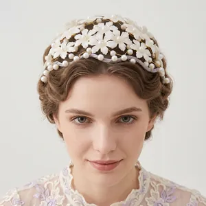 Close-up detail of a handmade white floral headband with pearls worn by a model