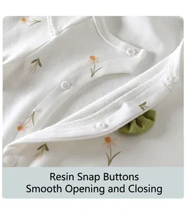 Close-up of baby romper with white resin snaps and floral pattern