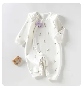 Detailed view of soft cotton baby girl romper with purple bow and floral print